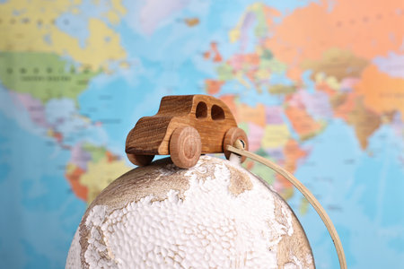 Wooden toy car on globe against world map, closeup. Road tripの写真素材