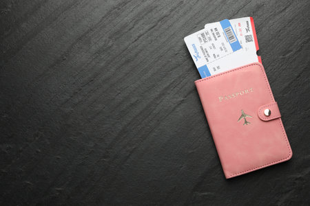 Flight tickets and passport on dark textured table, top view. Space for textの写真素材