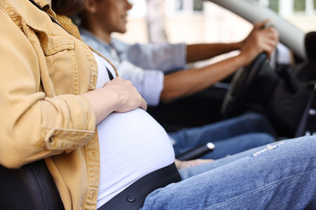 Pregnant woman travelling with her husband by car, closeupの写真素材