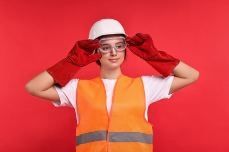 Girl with safety equipment on red background. Work for teenagersの写真素材