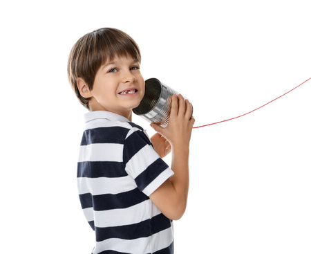 Boy using tin can telephone on white backgroundの写真素材