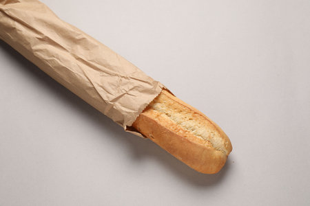 Paper bag with fresh baguette on beige background, top viewの写真素材