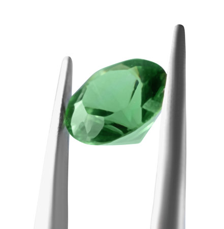 Tweezers with shiny green gemstone isolated on white