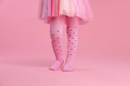 Child wearing tights on pink background, closeupの写真素材