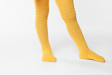 Child wearing bright tights on white background, closeup