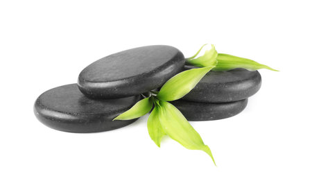 Spa stones and green leaves isolated on whiteの写真素材