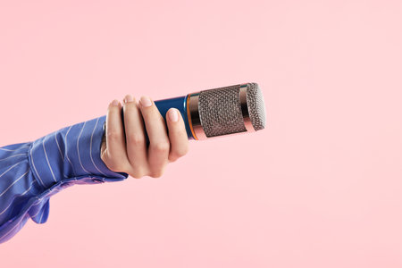 Woman with microphone on pink background, closeupの写真素材