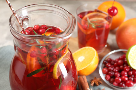 Tasty punch drink in glass jug and ingredients on table, closeupの写真素材
