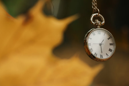 Autumn time. Chain watch on blurred background, closeup with space for text