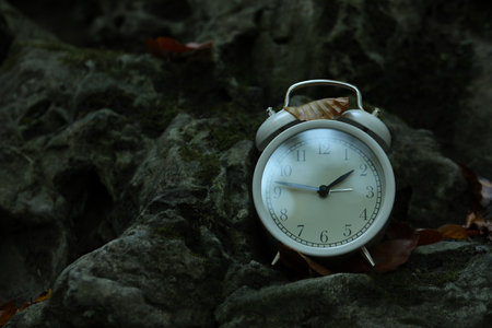Alarm clock on stones outdoors, closeup. Space for text