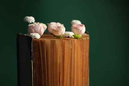 Book with beautiful flowers against green background, closeupの写真素材