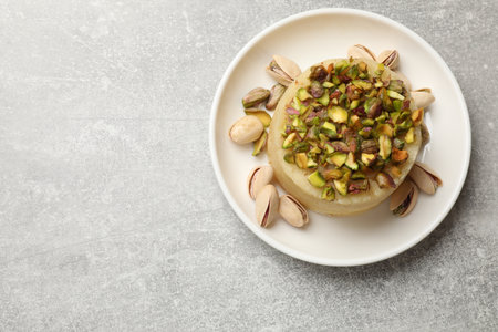 Delicious sweet semolina halva with pistachios on light gray table, top view. Space for textの写真素材