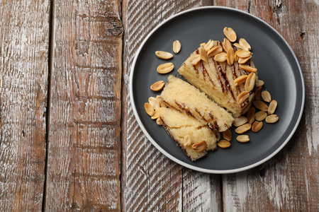 Delicious sweet semolina halva with peanuts on wooden table, top view. Space for textの写真素材
