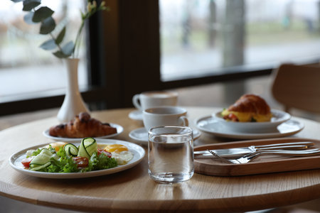 Delicious breakfast served on wooden table in cafeの写真素材