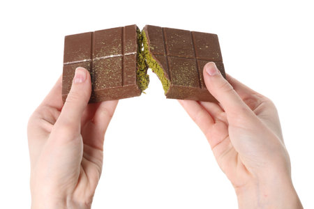 Woman breaking Dubai chocolate bar with pistachio and knafeh on white background, closeup