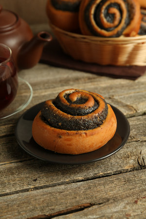 Tasty bun with poppy seeds on wooden table, closeupの写真素材