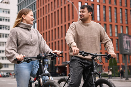 Beautiful happy couple with bicycles spending time together outdoorsの写真素材