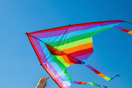 Woman with colorful kite against blue sky, closeupの写真素材