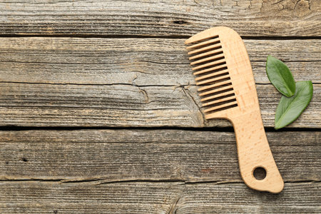 Comb and leaves on wooden table, flat lay. Space for textの写真素材