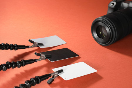 White balance calibration cards and camera on red background, closeup