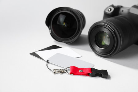 White balance calibration cards and camera on light background, closeup