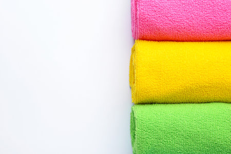 Rolled different microfiber cloths on white background, top view. Space for textの写真素材