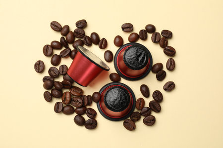 Coffee capsules and beans on beige background, flat layの写真素材