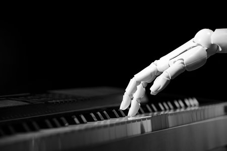 Artificial intelligence. Robot hand playing piano on black background, closeupの写真素材