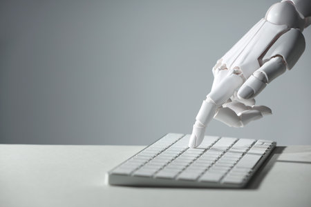Artificial intelligence. Robot hand using keyboard at light table against grey background, closeup. Space for textの写真素材