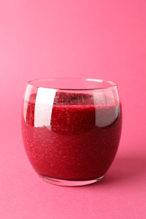 Fresh beetroot smoothie in glass on pink background, closeup