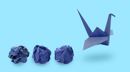 Origami crane and crumpled paper balls on light blue background, banner design. Transformation or new ideas conceptの写真素材