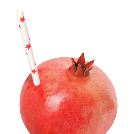 Ripe pomegranate with drinking straw on white background. Organic juice or freshly made smoothie conceptの写真素材