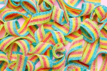 Tasty rainbow sour belts on pink background, top viewの写真素材