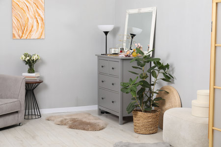 Mirror, dresser, different beauty products and houseplant indoorsの写真素材