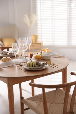 Stylish table setting with beautiful dishware and autumn decor in dining roomの写真素材