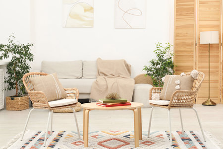 Light living room interior. Comfortable armchairs near table and other furniture indoorsの写真素材