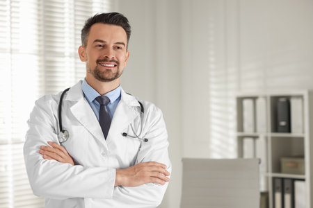 Smiling doctor with stethoscope in clinic, space for textの写真素材