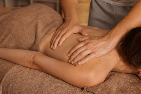 Osteopath massaging woman's back on couch indoors, closeup. Manual therapyの写真素材