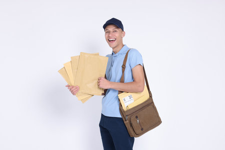 Happy postman with bag and envelopes on white backgroundの写真素材