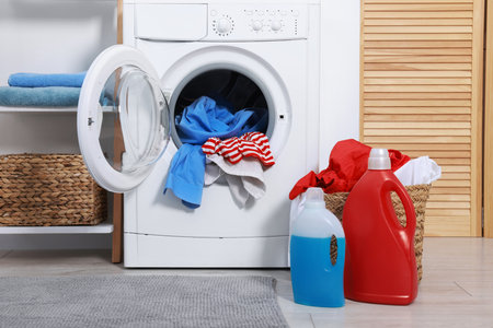 Washing machine, detergents and basket with laundry in roomの写真素材