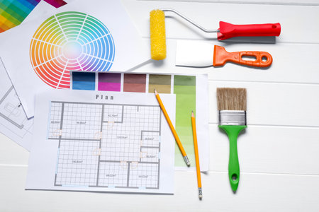 Designer's workplace with different color palettes, floor plans and pencil on white wooden table, flat layの写真素材