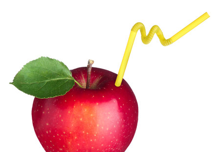 Ripe red apple with drinking straw on white background. Organic juice or freshly made smoothie conceptの写真素材