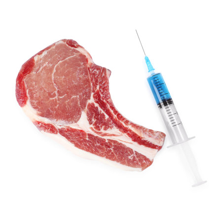 GMO concept. Pork steak and syringe isolated on white, top viewの写真素材