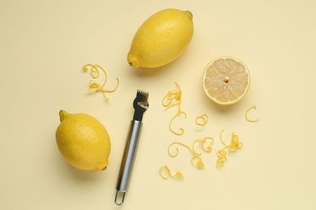 Lemon zest, zester tool and fresh fruits on beige background, flat layの写真素材