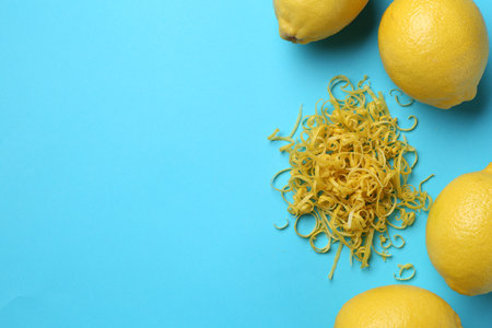 Lemon zest and fresh fruits on light blue background, flat lay. Space for textの写真素材