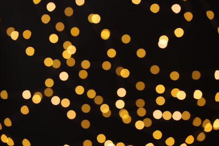Blurred view of golden lights on black background, bokeh effectの写真素材