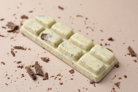 Tasty chocolate bar and crumbs on beige background, closeupの写真素材