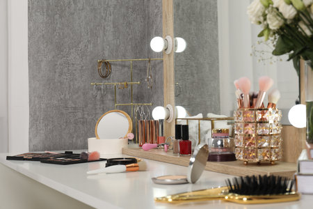 Makeup room. Mirror, different beauty products and jewelry on dressing table indoorsの写真素材