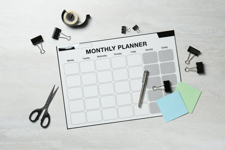 Timetable. Monthly planner and stationery on white wooden table, flat layの写真素材