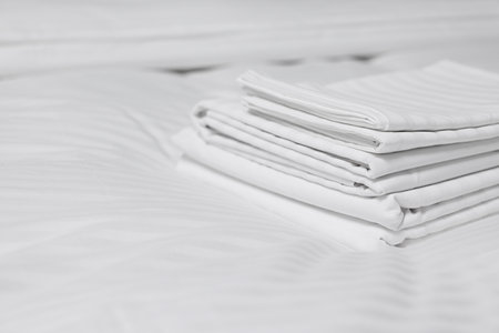 Stack of clean lines on bed indoors, closeup. Space for textの写真素材